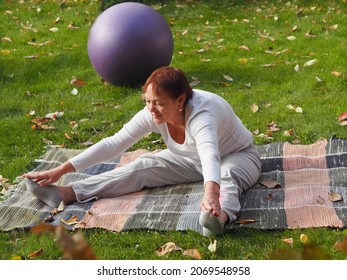 Una anciana practica yoga al aire libre. La práctica del yoga nos revive a la vida, restaura la condición moral y física.