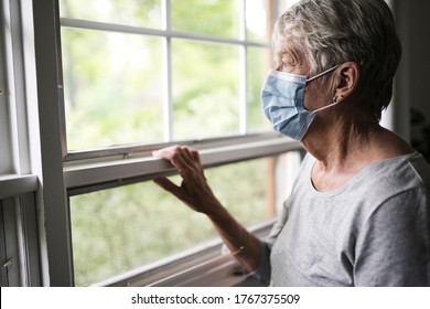 Elderly Woman In A Protective Mask In Front Of Window