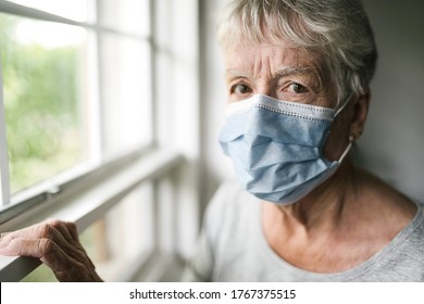 Elderly Woman In A Protective Mask In Front Of Window