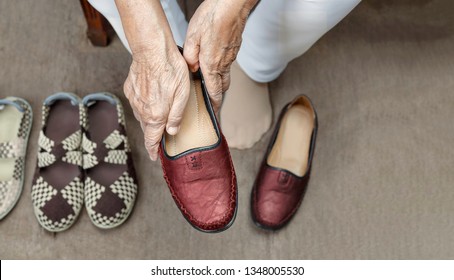 Elderly Woman Putting On Shoes