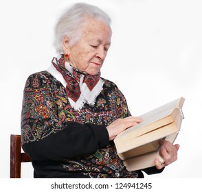 The elderly woman reads the book on a white background