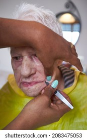 Elderly Woman Receiving Facial Hair Removal From African American Caregiver
