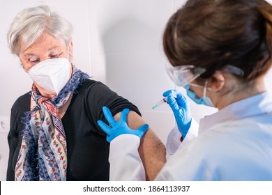 An elderly woman receiving the injection of the coronavirus vaccine by a doctor to receive the antibodies, immunize the population. side effects, risk people, antibodies, new normal, covid-19. - Powered by Shutterstock