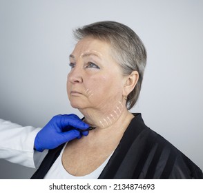 An elderly woman at the reception of a facial plastic surgeon. Consultation on the removal of age wrinkles on the face. The doctor shows what procedures he will do. Mimic wrinkles. Contour plastic - Powered by Shutterstock