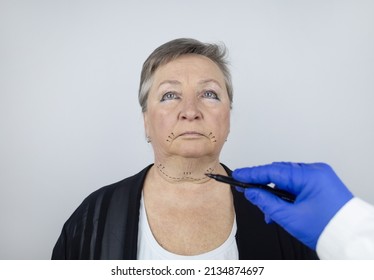 An elderly woman at the reception of a facial plastic surgeon. Consultation on the removal of age wrinkles on the face. The doctor shows what procedures he will do. Mimic wrinkles. Contour plastic - Powered by Shutterstock