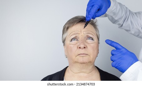 An elderly woman at the reception of a facial plastic surgeon. Consultation on the removal of age wrinkles on the face. The doctor shows what procedures he will do. Mimic wrinkles. Contour plastic - Powered by Shutterstock