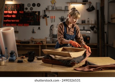 Elderly Woman Restoring Old Wooden Arm Chair by Removing Upholstery. Concept of repair and restoration old furniture. Copy space