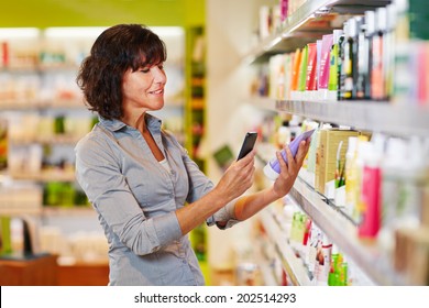 Elderly Woman Scanning Barcode Of Cosmetics Product In A Drugstore