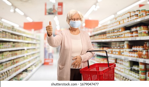 Elderly Woman Shopping In A Supermarket With A Protective Face Mask And Showing Thumbs Up