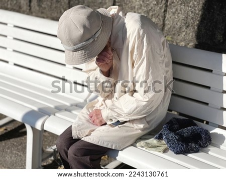 Elderly woman sitting on a bench and crying