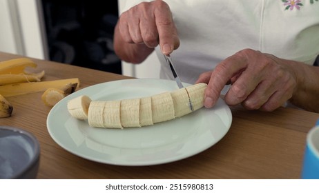 Elderly woman slicing banana at table, showcasing a simple and serene moment of daily life in a cozy home environment - Powered by Shutterstock