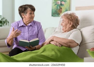 Elderly woman spending time with her sick friend in hospital
