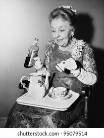 Elderly woman spiking her tea