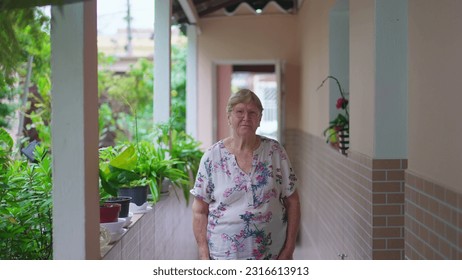 Elderly woman standing at home in casua South American Residence backyard. Senior female person in 70s, domestic authentic real people
