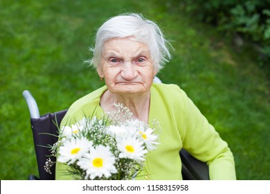 Elderly Woman Suffering From Dementia Disease Receiving Flowers For Her Birthday