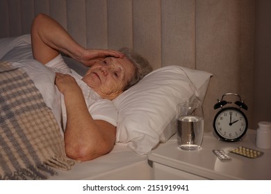 Elderly Woman Suffering From Insomnia In Bed At Home