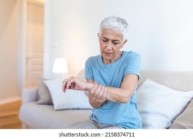 Elderly woman suffering from pain in hand, arthritis old person and senior woman female suffering from pain at home