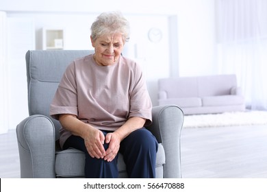 Elderly Woman Suffering From Pain In Knee At Home