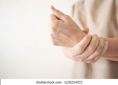 Elderly woman suffering from pain, weakness and tingling in wrist. Causes of hurt include osteoarthritis, rheumatoid arthritis, gout or wrist sprain. Health care concept. Copy space. - Powered by Shutterstock