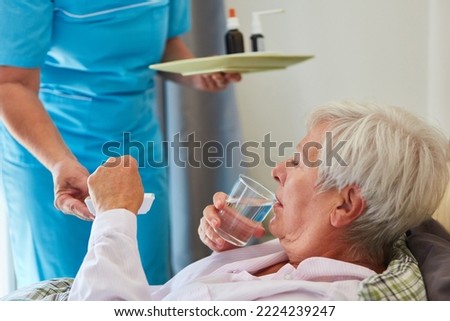 Similar – Female doctor giving medication to elderly patient