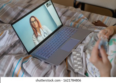 An Elderly Woman Is Talking With A Doctor On Skype. A Pensioner Suffers From A Respiratory Disease And Blows Her Nose. Online Consultation.