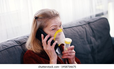 Elderly Woman Using Oxygen Inhaler While Speaking On The Phone. Coronavirus Outbreak And Vulnerable Group Of People. High Quality Photo