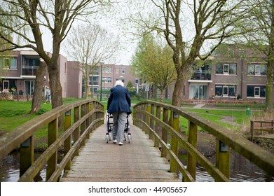 Elderly Woman With Walker On The Bridge