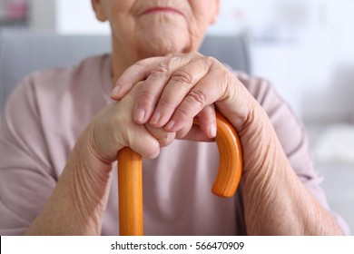 Elderly Woman With Walking Stick At Home, Closeup