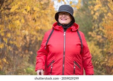 An Elderly Woman Walks In The Autumn Nature.