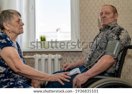 Similar – Senior woman in a wheelchair alone