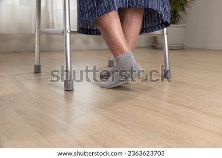 Elderly woman wear non slip grip socks for senior people who have trouble keeping their balance.