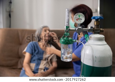 Elderly woman wearing oxygen nasal canula at home.