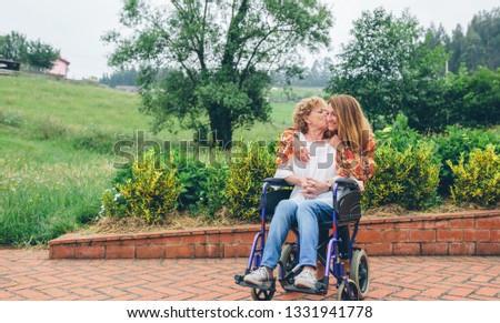 Similar – Daughter hugging senior mother in wheelchair