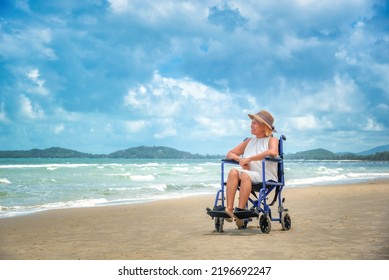 Elderly woman in wheelchair on tropical beach in summer in sunset - Powered by Shutterstock