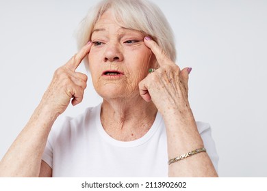 elderly woman in a white t-shirt poor eyesight light background