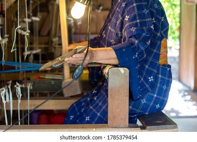An elderly woman working with weaving clothes and produces hand-woven according to ancient tradition. weaving and tailoring,Japanese style, Selective focus