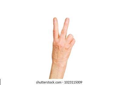 Elderly woman, wrinkled hand w/ clearly visible veins showing traditional victory peace sign gesture. Old lady arms, freckles. Isolated white background, close up, overhead, copy space.