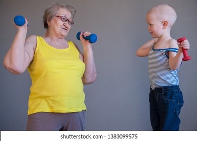 elderly woman in yellow T-shirt and sportswear does gymnastics with dumbbells. Little boys grandchildren do exercises with their grandmother. - Powered by Shutterstock