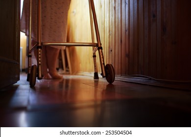 Elderly womans feet walking at home with aid of walker. Difficulty of life in old age