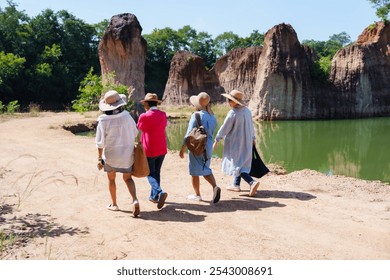 Elderly women friends exploring a scenic area with unique rock formations near a lake. Their bright attire and friendly conversation reflect enjoyment and companionship on their nature outing. - Powered by Shutterstock