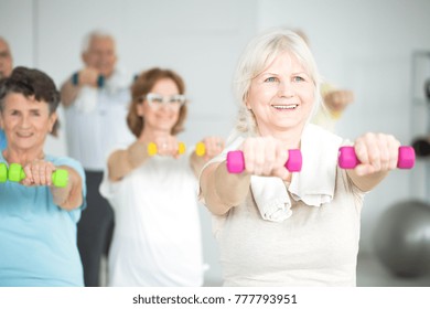 Mujeres de edad que llevan pancartas durante la clase de ejercicio grupal para adultos mayores
