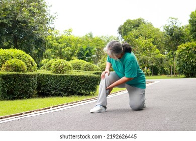 Elderly Women Jogging In The Park She Has Pain In Her Right Knee. Concept Of Health Care To Be Healthy In Retirement Age. Bone Disease In The Elderly