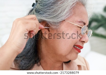 Elderly women use cotton buds to pick up earwax. Causing some of the earwax to stick to the eardrum causing the earwax to clog. concept of health care nursing Foto stock © 