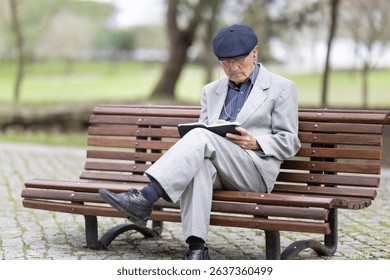 Elderly writer taking notes in a notebook while sitting on a bench in the park