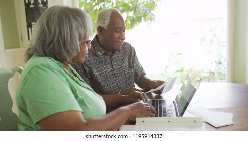 Eldery black man looking at bills with wife - Powered by Shutterstock