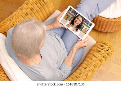 E-learning concept: senior woman with tablet computer watching an online english lesson.