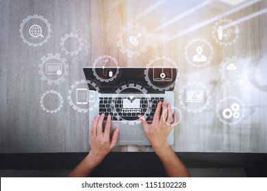 E-learning with connected gear cogs connected diagram virtual dashboard.top view of Designer hand working with laptop computer on wooden desk as responsive web design concept - Shutterstock ID 1151102228