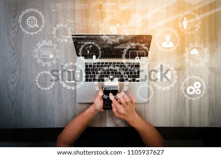 E-learning with connected gear cogs connected diagram virtual dashboard.top view of Designer hand working with laptop computer and smarth phone and digital tablet on wooden desk as responsive web 