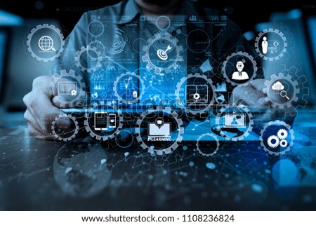 E-learning with connected gear cogs connected diagram virtual dashboard.businessman hand working with modern technology digital tablet computer and digital layer effect as business strategy concept