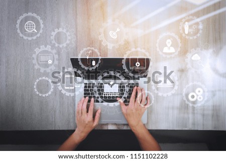 E-learning with connected gear cogs connected diagram virtual dashboard.top view of Designer hand working with laptop computer on wooden desk as responsive web design concept